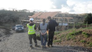 Clients look over their roundwood timber frame home.